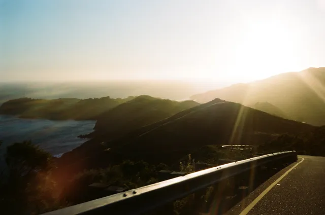 Flare over the headlands: film photograph by Ben Enbom, USA